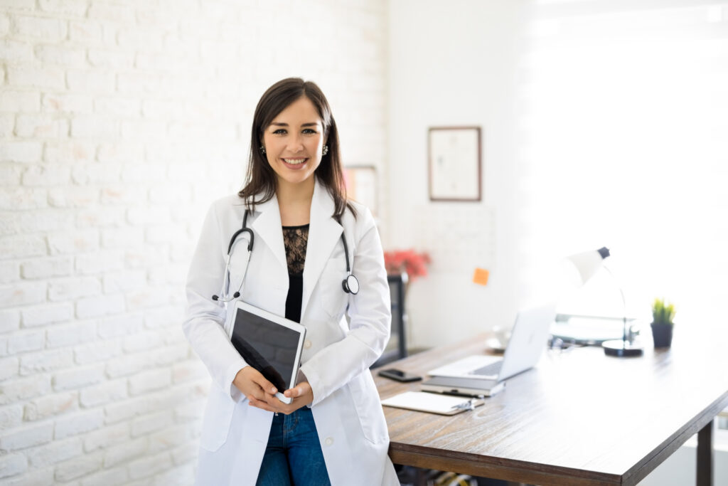 Portrait,Of,Beautiful,Young,Female,Doctor,Standing,By,Her,Desk